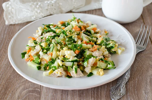 Salad with chicken, carrots, eggs and cucumbers — Stock Photo, Image