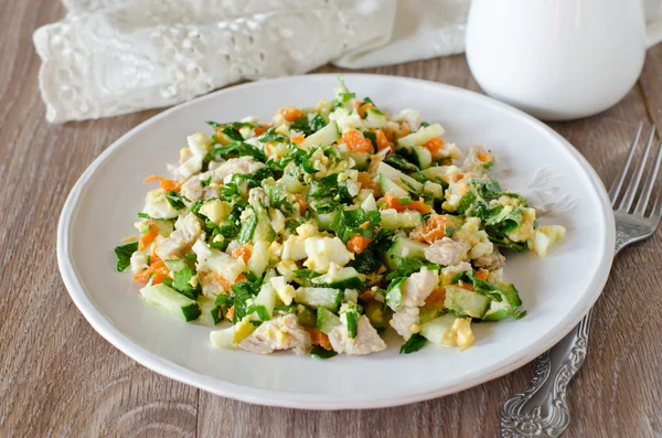 Salad with chicken, carrots, eggs and cucumbers — Stock Photo, Image