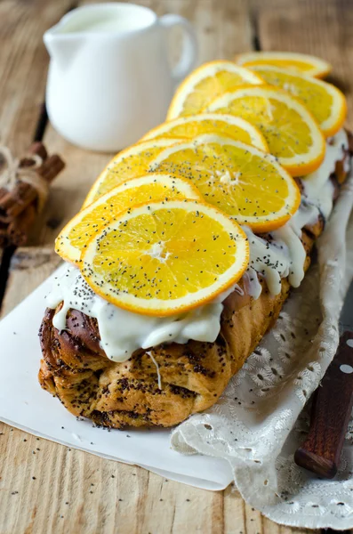 Yeast roll with poppy seeds, cream and oranges — Stock Photo, Image