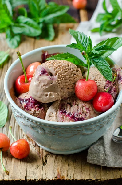 Čokoládová zmrzlina s cherry v misce na dřevěný stůl — Stock fotografie