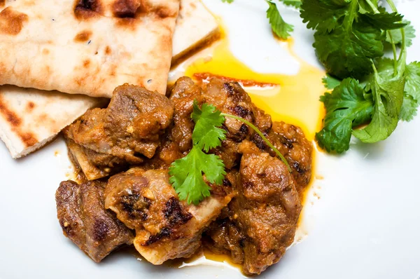 kuzu köri kişniş ve naan beyaz bir plaka üzerinde kapat
