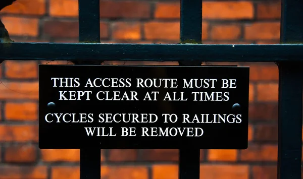 Imagem de close-up do sinal de alerta para ciclista em uma faculdade em Cambridge, Inglaterra — Fotografia de Stock