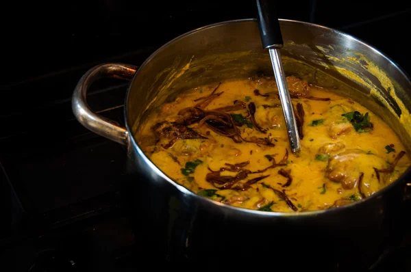 Verse pakora curry in een pan op een zwarte achtergrond, tarka — Stockfoto