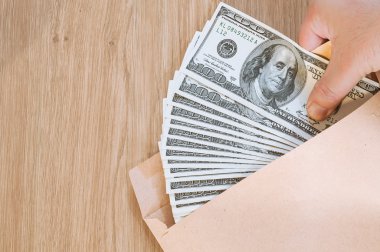 Handling money in brown envelop, bribe clipart