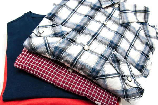 Pile of Shirts and T Shirts in different colors isolated on white — Stock Photo, Image