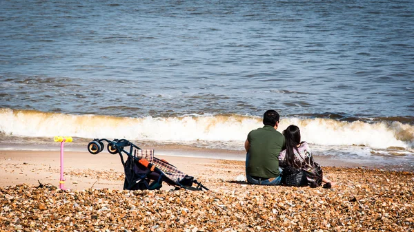 Ευτυχισμένη οικογένεια κάθεται σε μια παραλία — Φωτογραφία Αρχείου
