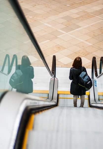 A shopper going down an escalator in a shopping mall — Stock Photo, Image