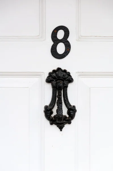 Deur nummer 8 en deur knocker close-up voor gebruik als achtergrond — Stockfoto