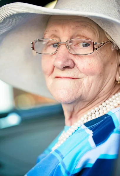 Old woman sitting in automobile — Stock Photo, Image