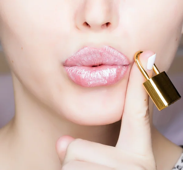 Woman holding gold lock on finger — Stock Photo, Image