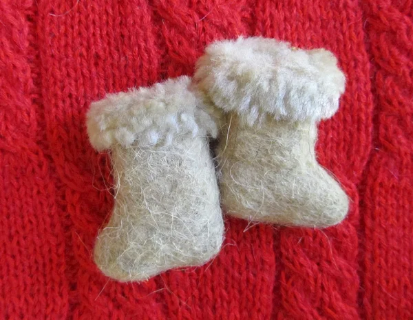 Small felt boots on red sweater closeup — Stock Photo, Image