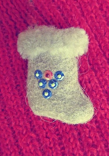 Felt boot with sequins on a red sweater closeup — Stock Photo, Image