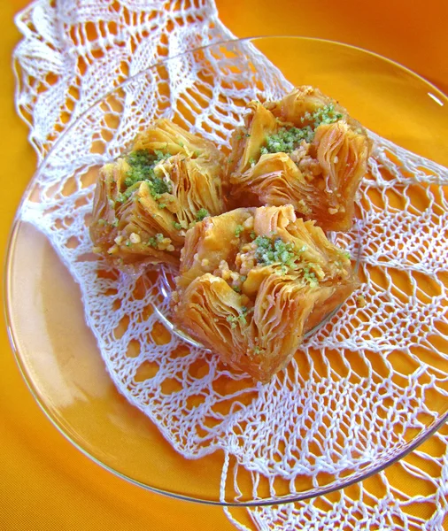 Baklava doce em pires em toalha de mesa laranja, close-up — Fotografia de Stock