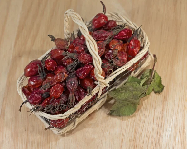 Сушеные ягоды шиповника в плетеной корзине, крупным планом — стоковое фото