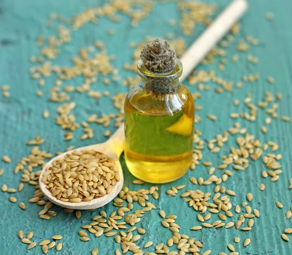 Aceite de linaza en botella sobre fondo de madera — Foto de Stock