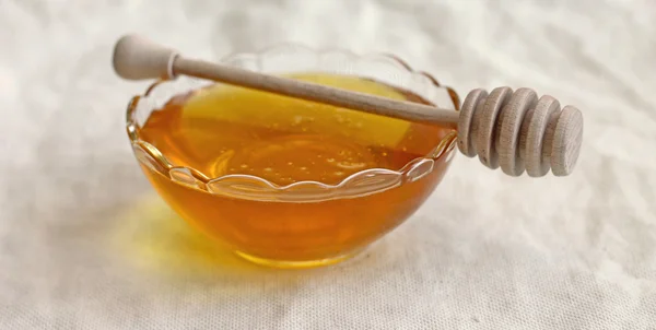 Чаша мёда с деревянным дождевателем, крупным планом — стоковое фото
