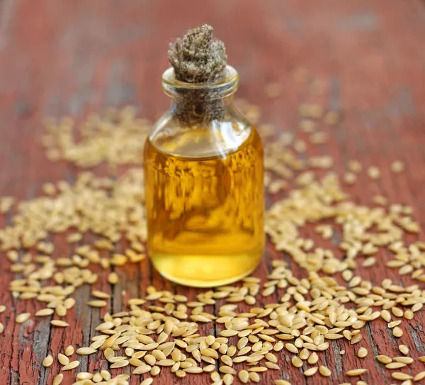 Aceite de linaza en botella sobre fondo de madera — Foto de Stock