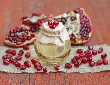 Nar çekirdeği yağı şişe kırmızı ahşap zemin üzerinde kapat-u