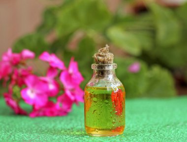 Geranium oil in glass bottle clipart