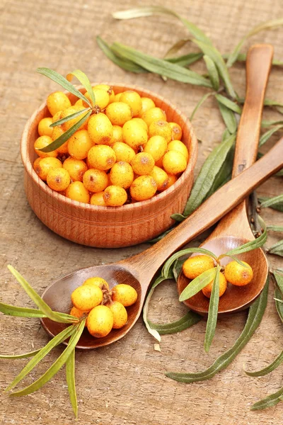 Bacche di olivello spinoso fresche in ciotola di legno — Foto Stock