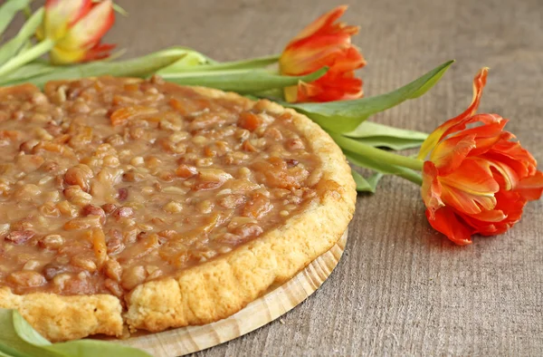 Appetizing caramel flan with tulips, close-up — Stock Photo, Image