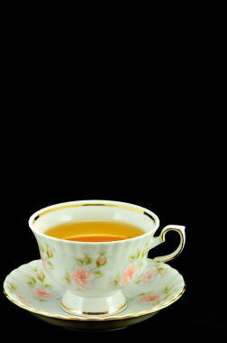 Porselen çay bardağı çay ve yeşil çaydanlık üstünde siyah bir backgr dolu