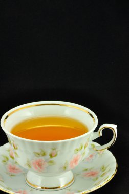 Porselen çay bardağı çay ve yeşil çaydanlık üstünde siyah bir backgr dolu