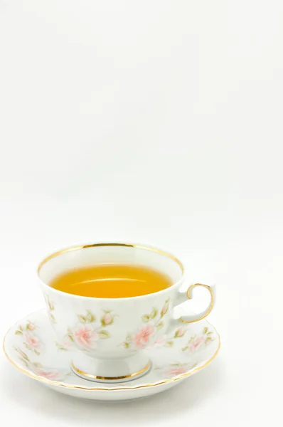 Xícara de chá de porcelana cheia de chá em um fundo branco — Fotografia de Stock