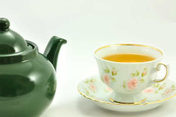 Uma xícara de chá e bule verde em um fundo branco — Fotografia de Stock