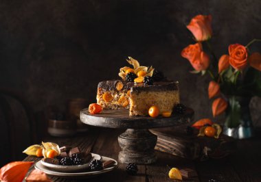 Felsefeli, böğürtlenli, güllü lezzetli çikolatalı pasta, ahşap arka planda klasik yemekler. Sonbahar renklerinde tatlı ile hayat..