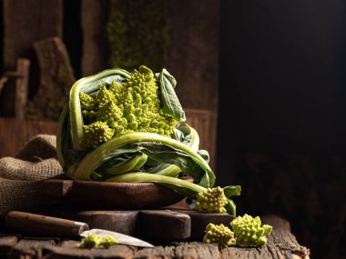 Tahta tahtada çiğ Romanesco lahanası. Koyu renkte sebze fotoğrafı. Kapatın..