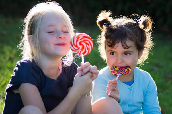 Niños con caramelos de piruleta — Foto de Stock