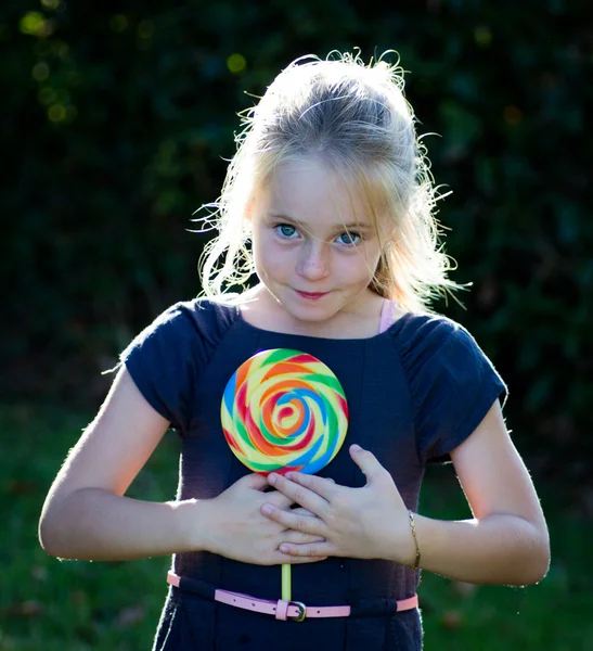 Liten flicka med lollipop godis — Stockfoto