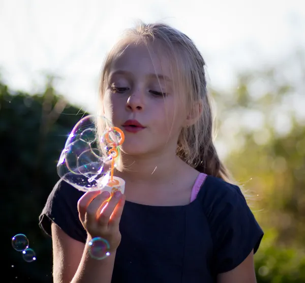 Little girl playing with bubbles — Stock Photo, Image