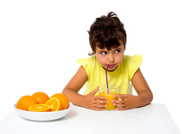 Liten flicka med glas apelsinjuice — Stockfoto