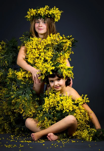 Små piger med blomster kjoler - Stock-foto