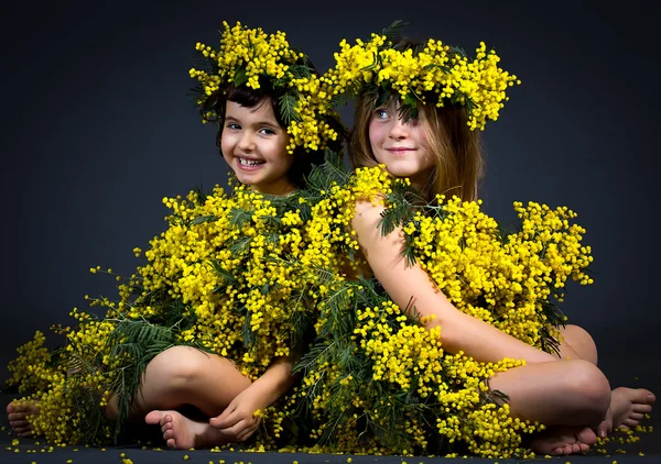 Små flickor med blommiga klänningar — Stockfoto