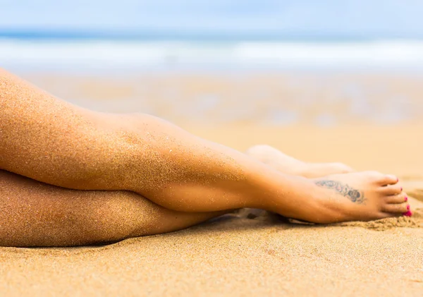 Gambe di donna sulla spiaggia — Foto Stock