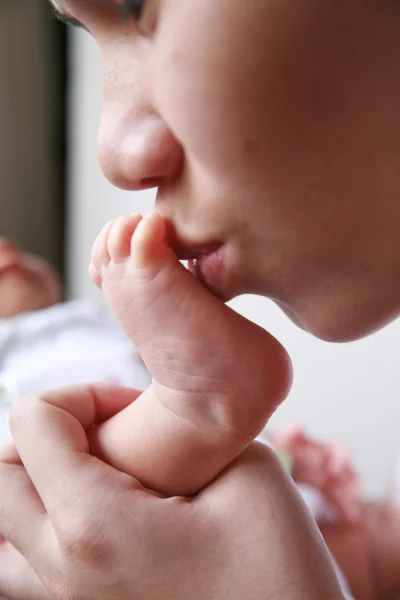 Mother kiss baby's foot — Stock Photo, Image