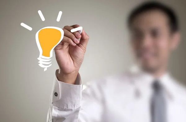 Hand with a pen drawing light bulb — Stock Photo, Image