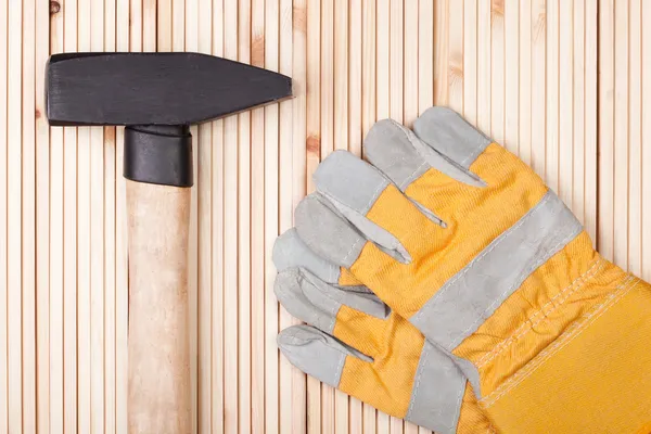 Hammer und Schutzhandschuhe. — Stockfoto