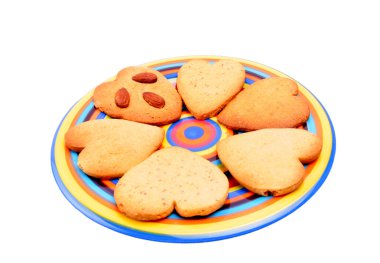 Beyaz arka plan üzerinde izole bisküvi varicoloured çanak üzerinde ev yapımı kalp şeklinde. Noel kurabiyeleri