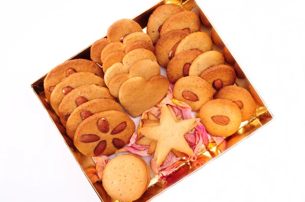 Christmas baking. Assorted biscuits in a gold box, isolated on white background — Stock Photo, Image