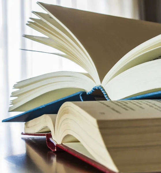 Books over wood table with window light background — Stock Photo, Image