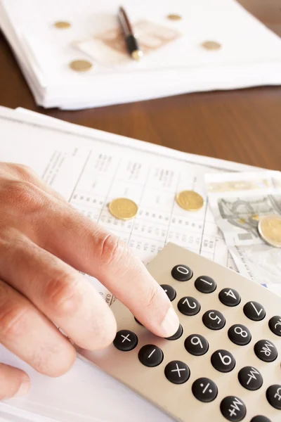 Hombre de negocios haciendo cuentas en la oficina con dinero y calculadora — Foto de Stock