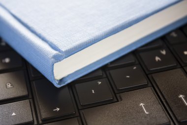 mavi kitap ile pencere ışık siyah bilgisayar üzerinde