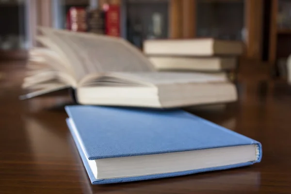 Muitos livros coloridos e moldados de tamanho diferente na mesa de madeira — Fotografia de Stock