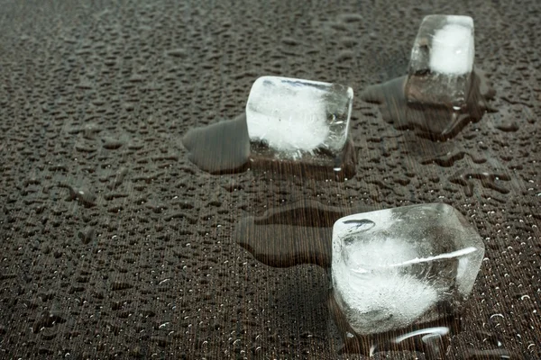 Cubes de glace sur fond de table en bois wengé humide — Photo