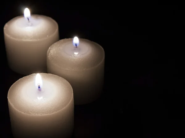 Bílé svíčky na tmavé pozadí, pojem náboženství — Stock fotografie