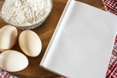 Composition.Flour ve boş kitabı ve kırmızı havlu ile yumurta pişirme